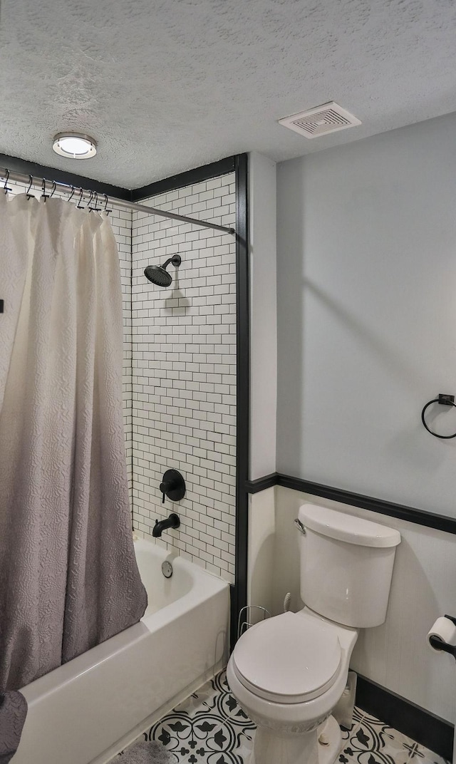 bathroom featuring shower / bath combination with curtain, a textured ceiling, toilet, and tile patterned floors