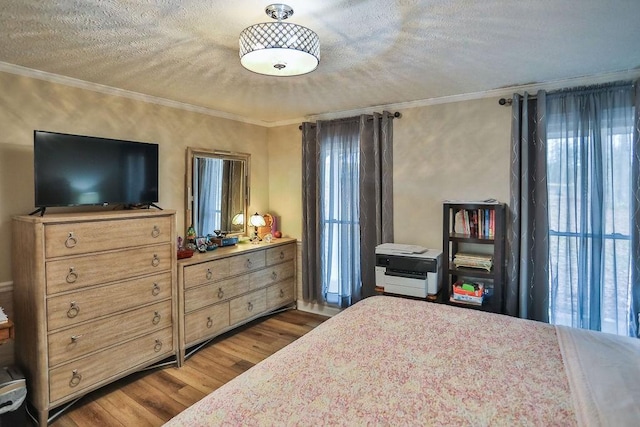 bedroom with crown molding, wood-type flooring, and a textured ceiling