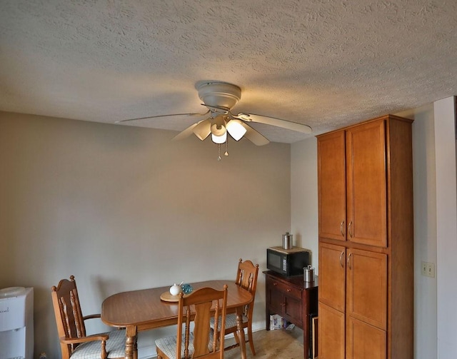 carpeted dining room featuring a textured ceiling and ceiling fan