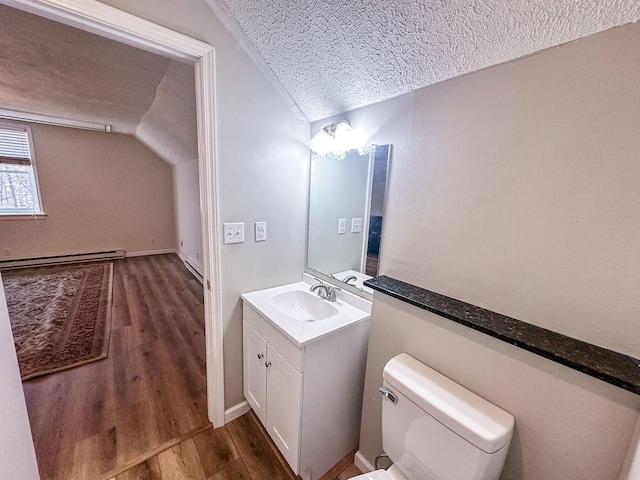 bathroom featuring a baseboard heating unit, vaulted ceiling, a textured ceiling, vanity, and wood finished floors