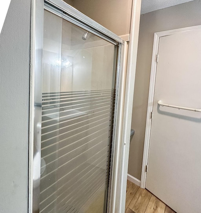 bathroom featuring a stall shower and wood finished floors