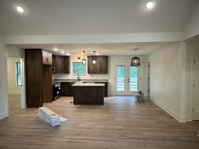 kitchen featuring french doors, a center island, light hardwood / wood-style floors, and hanging light fixtures