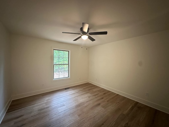 unfurnished room with dark hardwood / wood-style flooring and ceiling fan