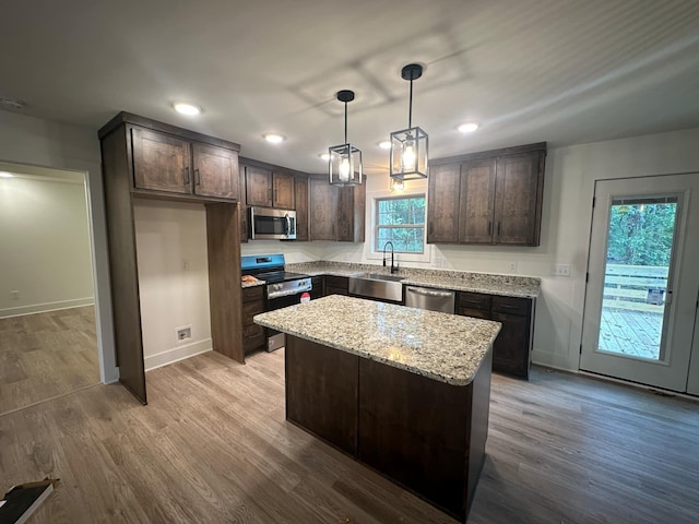 kitchen featuring a wealth of natural light, a center island, pendant lighting, and appliances with stainless steel finishes