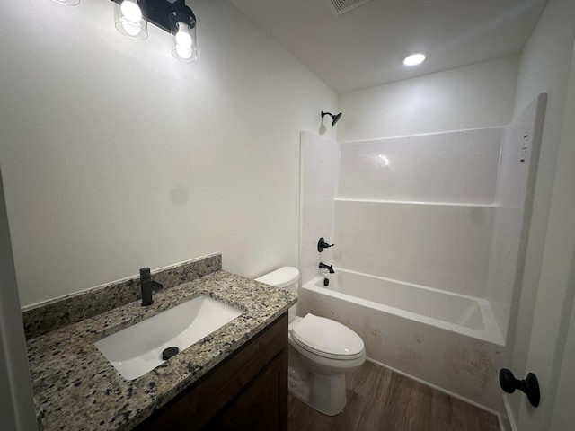 full bathroom with hardwood / wood-style floors, vanity, toilet, and tub / shower combination