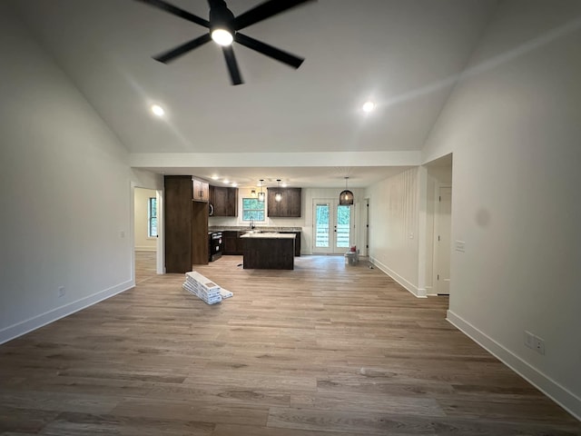 unfurnished living room featuring ceiling fan, hardwood / wood-style floors, high vaulted ceiling, and french doors