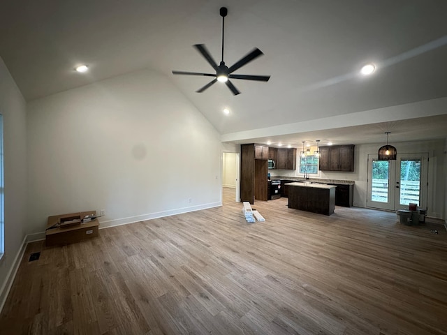 unfurnished living room featuring wood-type flooring, french doors, high vaulted ceiling, and ceiling fan