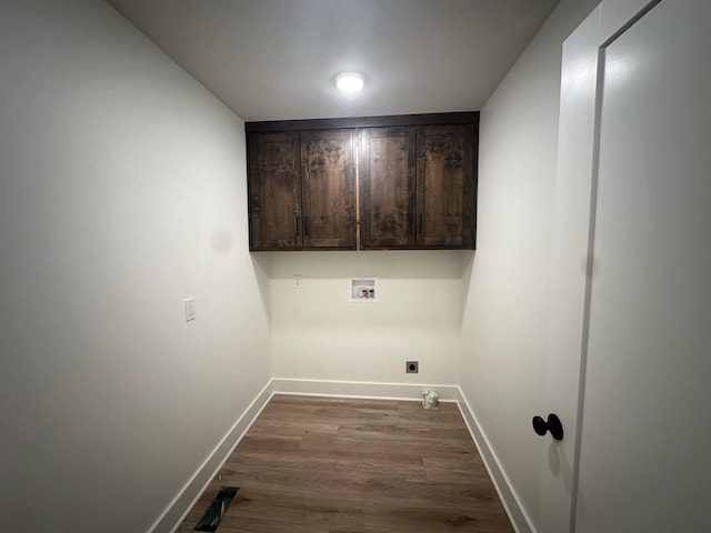 washroom with washer hookup, hookup for an electric dryer, dark hardwood / wood-style flooring, and cabinets