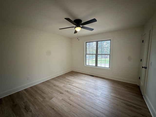 spare room with hardwood / wood-style floors and ceiling fan