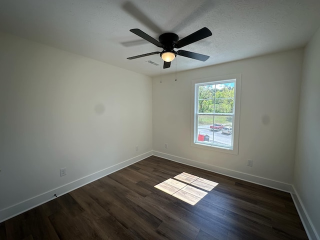 spare room with ceiling fan, dark wood-type flooring, and a textured ceiling