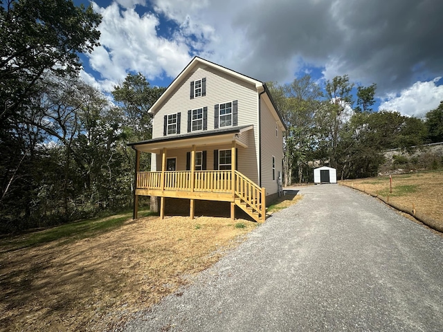 view of front of home featuring covered porch and a storage shed