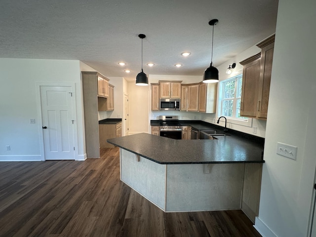 kitchen with kitchen peninsula, dark hardwood / wood-style flooring, stainless steel appliances, sink, and hanging light fixtures