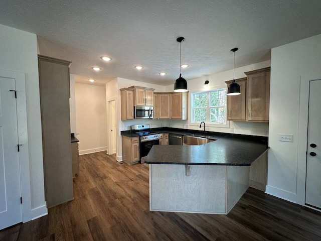 kitchen featuring pendant lighting, sink, dark hardwood / wood-style flooring, kitchen peninsula, and stainless steel appliances