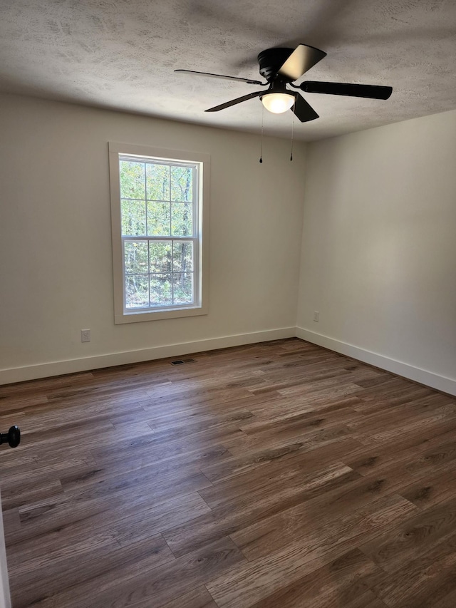 unfurnished room featuring a textured ceiling, ceiling fan, and dark hardwood / wood-style floors