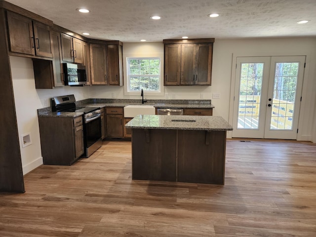 kitchen featuring dark stone counters, sink, appliances with stainless steel finishes, and french doors