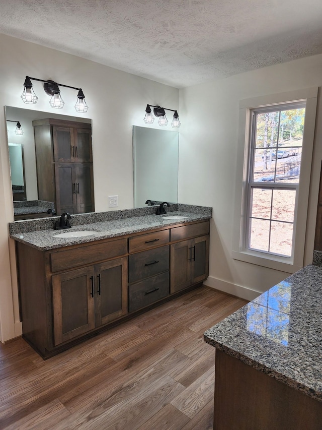 bathroom with vanity, a textured ceiling, and hardwood / wood-style flooring