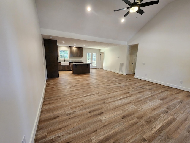 unfurnished living room featuring ceiling fan, light hardwood / wood-style floors, and high vaulted ceiling