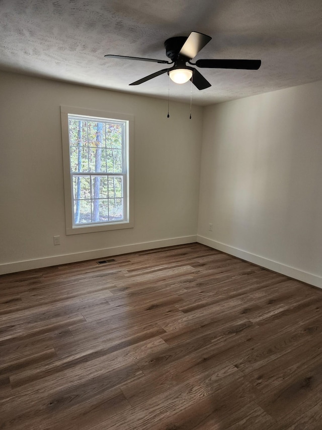 spare room featuring a textured ceiling, dark hardwood / wood-style flooring, and ceiling fan