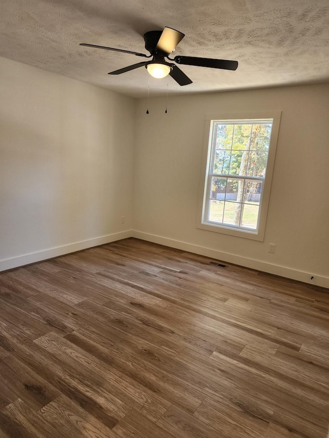 spare room with ceiling fan, hardwood / wood-style floors, and a textured ceiling