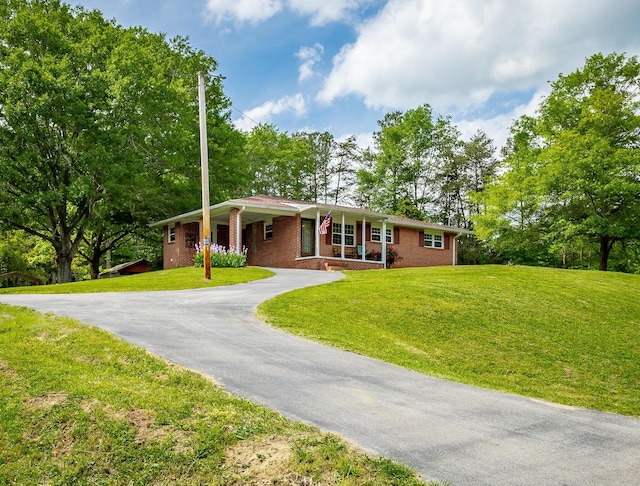 ranch-style house with a front yard and covered porch