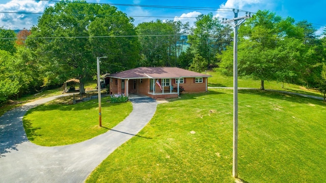 view of front of home featuring covered porch and a front lawn