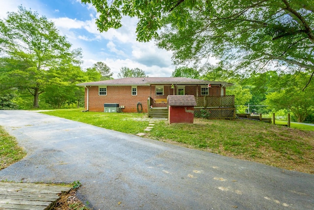 view of front of house with a front yard, central AC unit, and a wooden deck