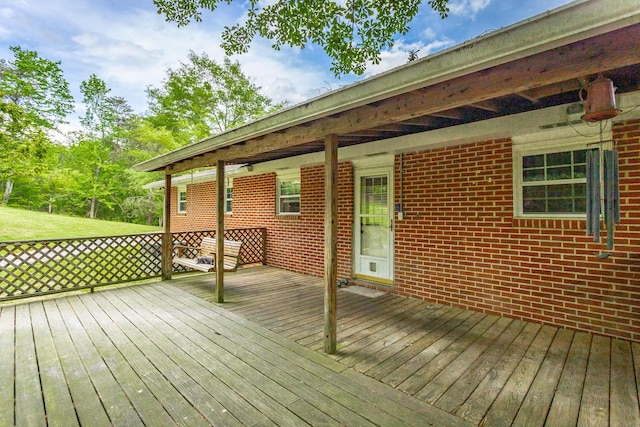 wooden deck featuring a lawn