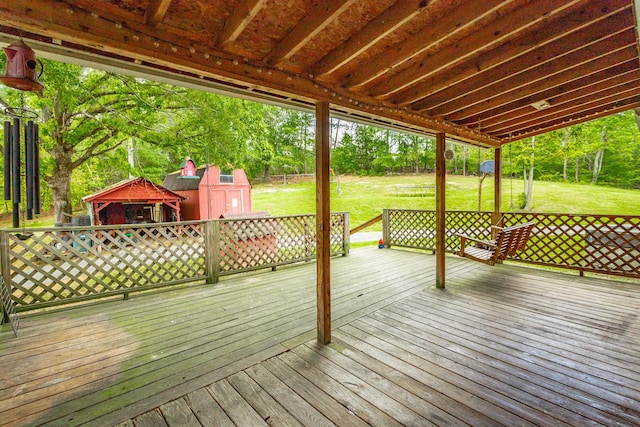 wooden deck featuring a lawn and a storage shed