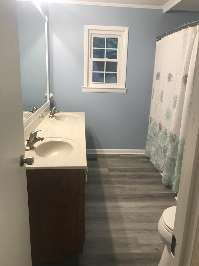 bathroom with hardwood / wood-style flooring, vanity, toilet, and crown molding