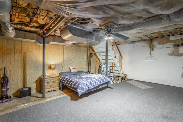 bedroom featuring ceiling fan and wood walls