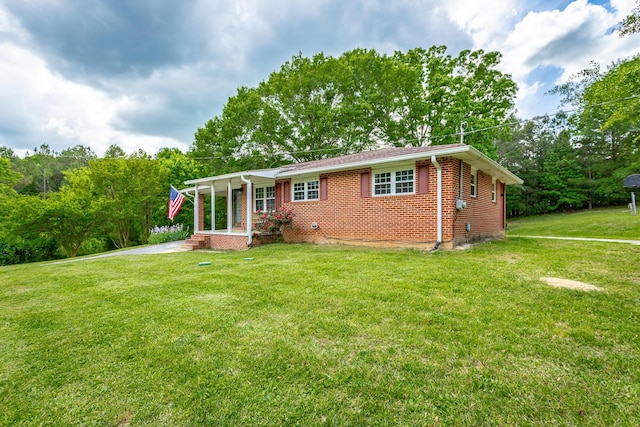 back of property featuring a lawn and covered porch