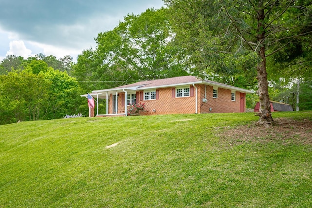 rear view of property with covered porch and a lawn