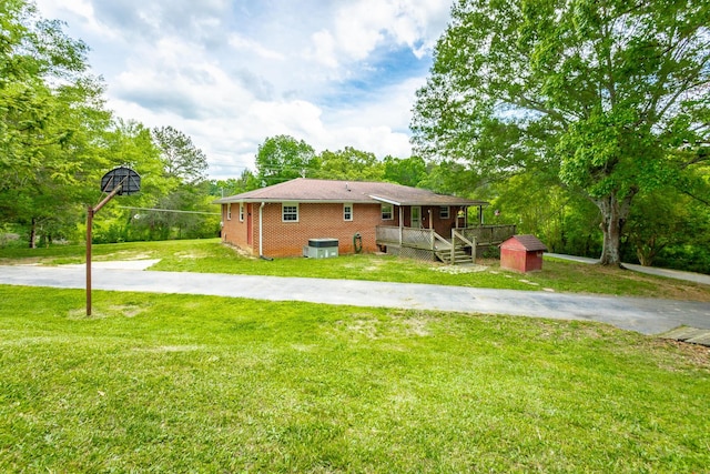 exterior space featuring a lawn, a porch, and a storage shed