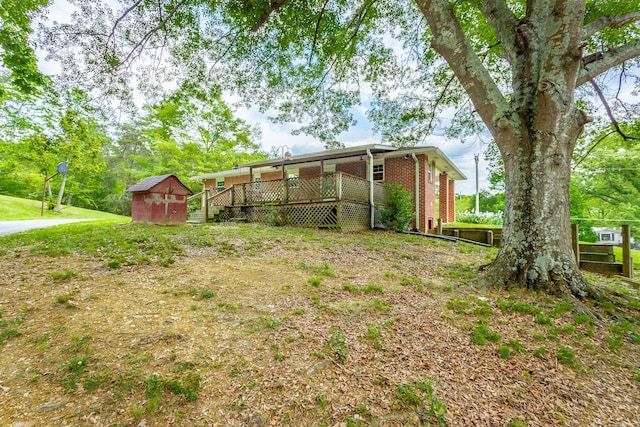 view of yard with a storage shed and a wooden deck