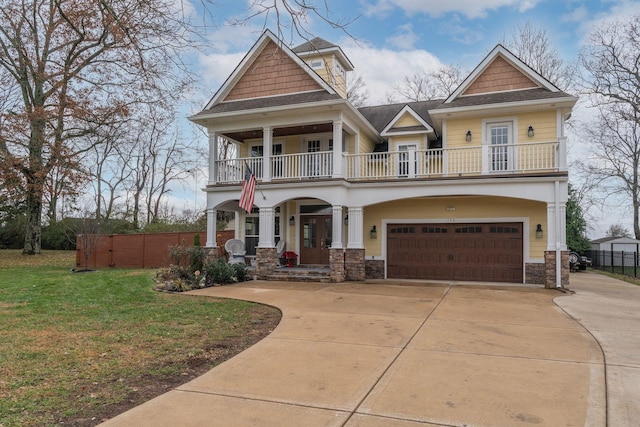 craftsman-style home featuring a balcony, a front yard, and a garage