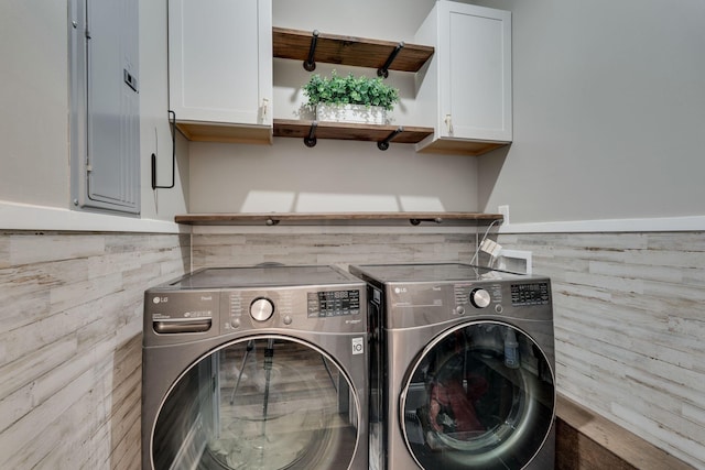 laundry room featuring cabinets, electric panel, and washer and clothes dryer