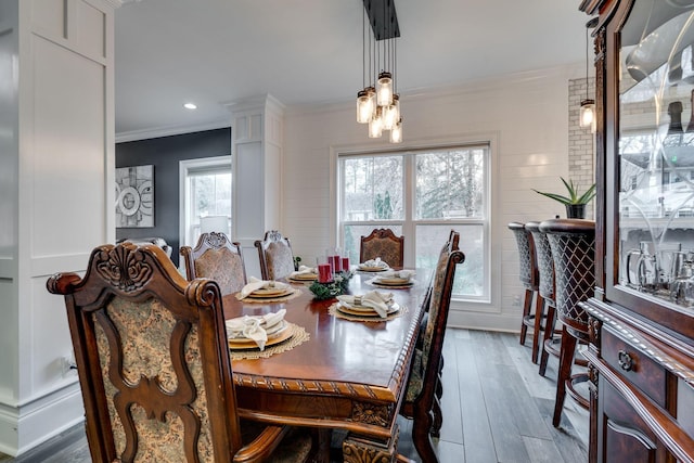 dining space with dark hardwood / wood-style floors, crown molding, and a healthy amount of sunlight