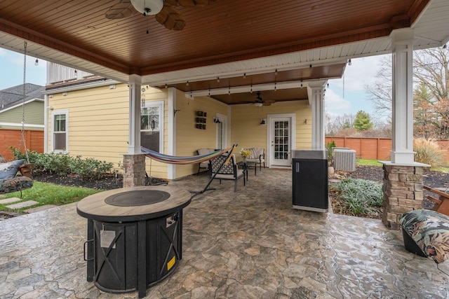 view of patio / terrace featuring a fire pit, ceiling fan, and cooling unit