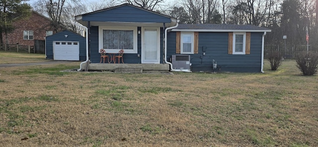 view of front of property featuring cooling unit, a garage, a front lawn, and an outdoor structure