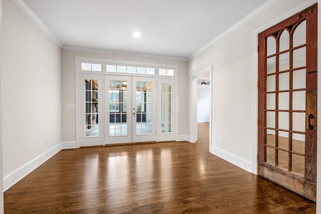 empty room featuring crown molding, dark wood-type flooring, and french doors