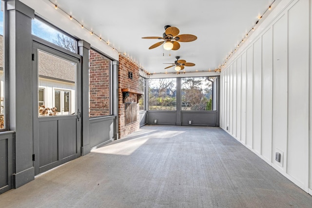 unfurnished sunroom featuring ceiling fan