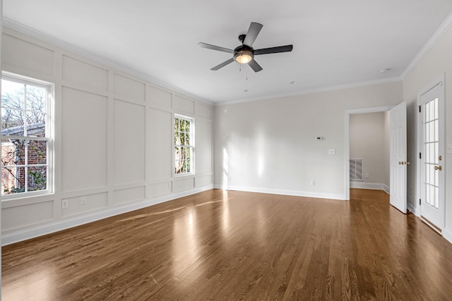 empty room with crown molding, plenty of natural light, and dark hardwood / wood-style floors