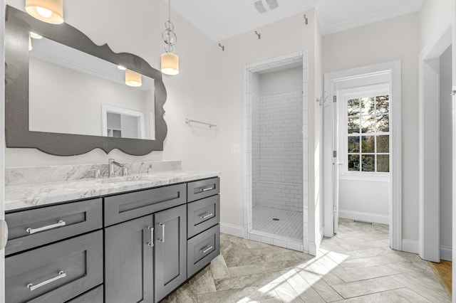 bathroom with ornamental molding, a tile shower, and vanity