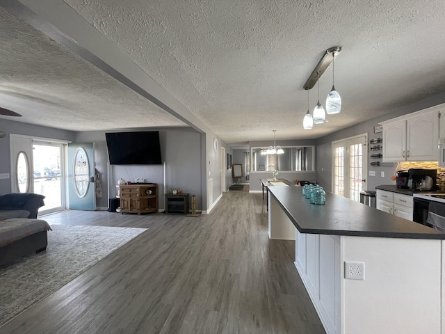 kitchen with dark countertops, open floor plan, and dark wood finished floors