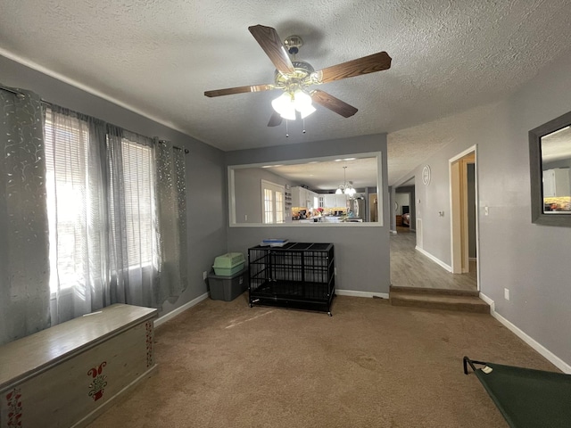 living room featuring a textured ceiling, carpet floors, and baseboards