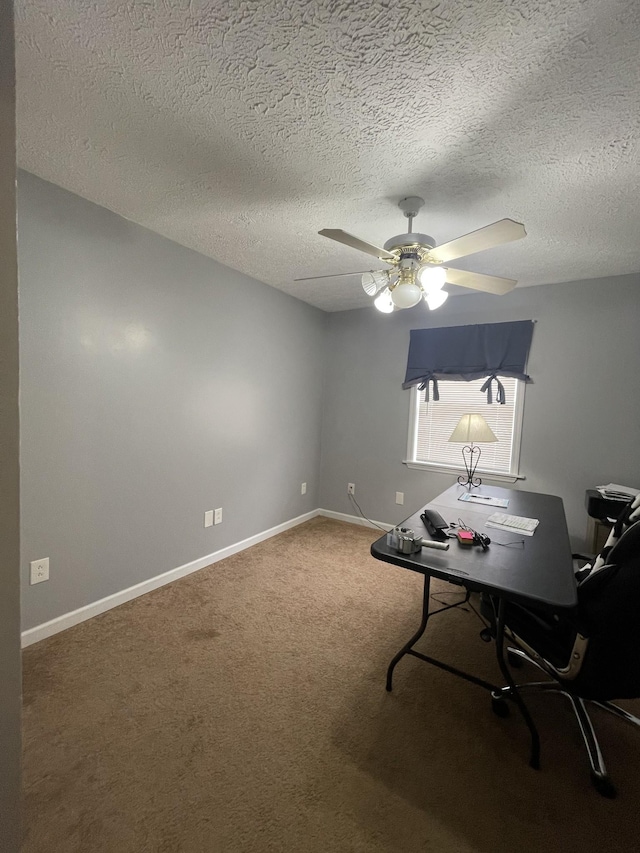 carpeted home office featuring ceiling fan, baseboards, and a textured ceiling