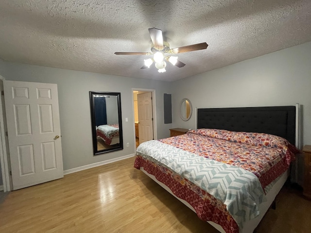 bedroom with a textured ceiling, ceiling fan, wood finished floors, and baseboards