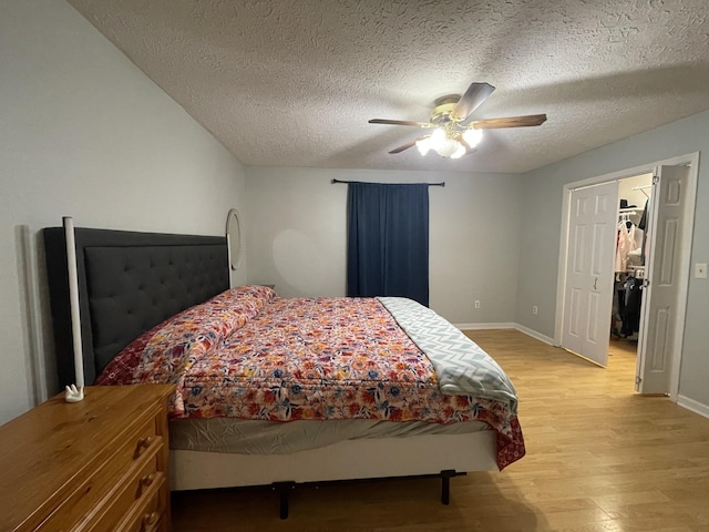 bedroom with light wood-style flooring, baseboards, ceiling fan, and a textured ceiling