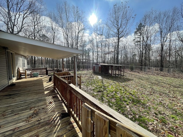 wooden terrace featuring fence and an outdoor structure