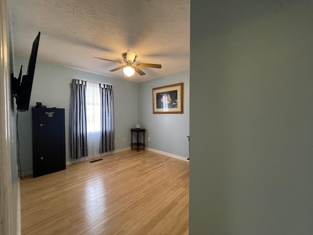 173 Twin Oaks Dr, Hohenwald, TN 38462 - empty room with a ceiling fan, a textured ceiling, and light wood-style floors